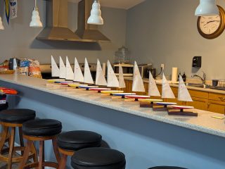 Full fleet of sailboat awards lined up on a counter