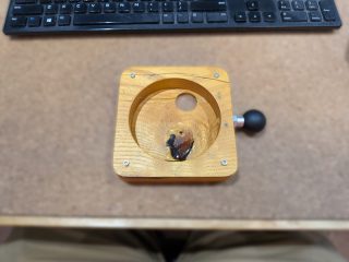 Raymarine display seated in the CNC-machined wood mount on a workbench