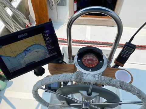 Custom teak binnacle mount installed on a sailboat, with chart plotter off to one side and compass in the centre